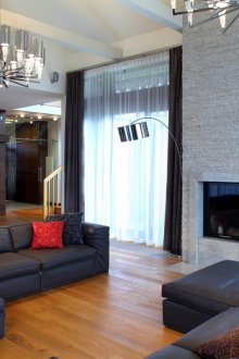 Grosses Wohnzimmer mit Kamin mit zwei Fenstern an einer Wand