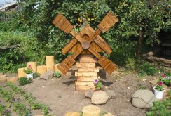 Dekoratívny mlyn vyrobený z dreva v záhrade