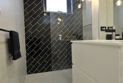Τοποθετήστε μαύρα πλακάκια διαγώνια στον τοίχο του μπάνιου