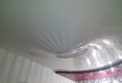 Draining water from a glossy stretch ceiling