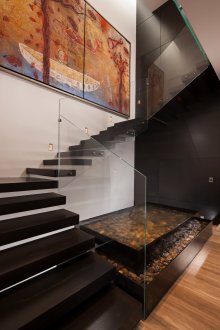 Black staircase with glass railing.