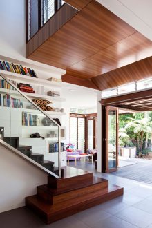 Wooden brown staircase with glass railing.