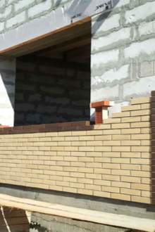 Frente a la casa con ladrillo amarillo