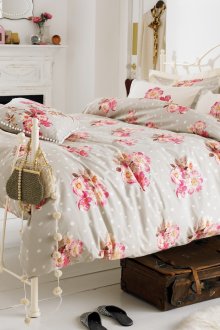 Provence-style bedroom with floral print on bedding and curtains