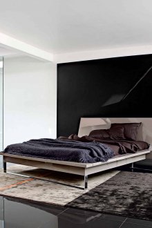 Minimalist bir yatak odasında bej, kahverengi, beyaz ve siyah.