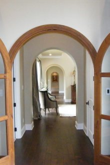 Diseño de pasillo con arco y puertas.