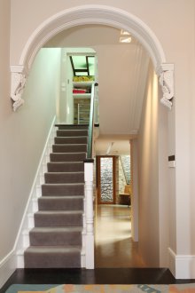 Diseño de pasillo con arco y decoración de yeso.