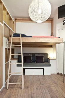 Bedroom in a studio apartment with wooden furniture