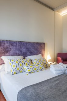 Habitación pequeña con cabecera decorativa.