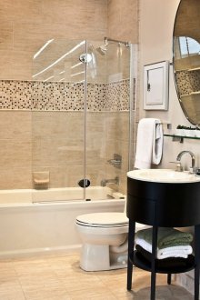 Koyu mobilyalarla bej banyo.