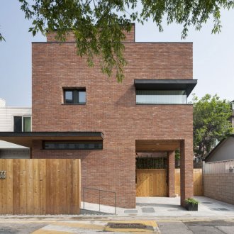 Casa minimalista con revestimiento de ladrillo rojo.