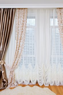 Tulle with embroidery and satin curtains in the bedroom interior