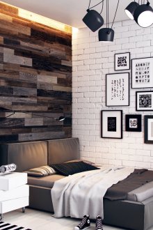 Pinturas em preto e branco em uma parede de tijolos em um quarto