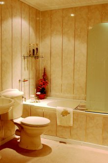 Design de banheiro dourado cremoso com painéis de PVC