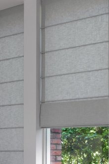 Beautiful gray roman curtains in the bedroom